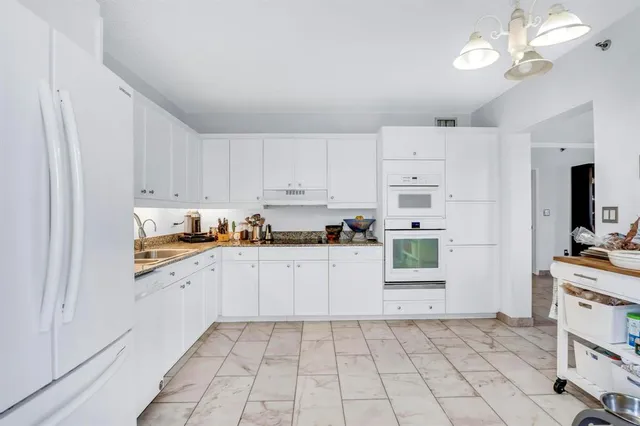 a kitchen with cabinets and chairs