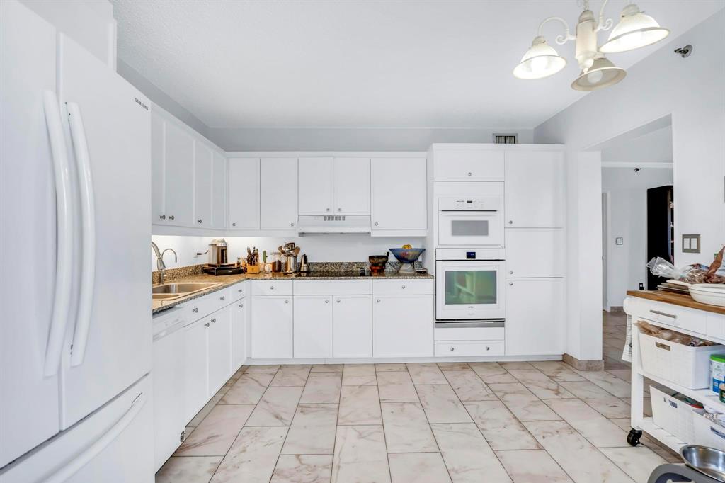 8855 Collins Avenue, Unit 2D Surfside, FL 33154 - Photo 8 of 25 a kitchen with cabinets and chairs