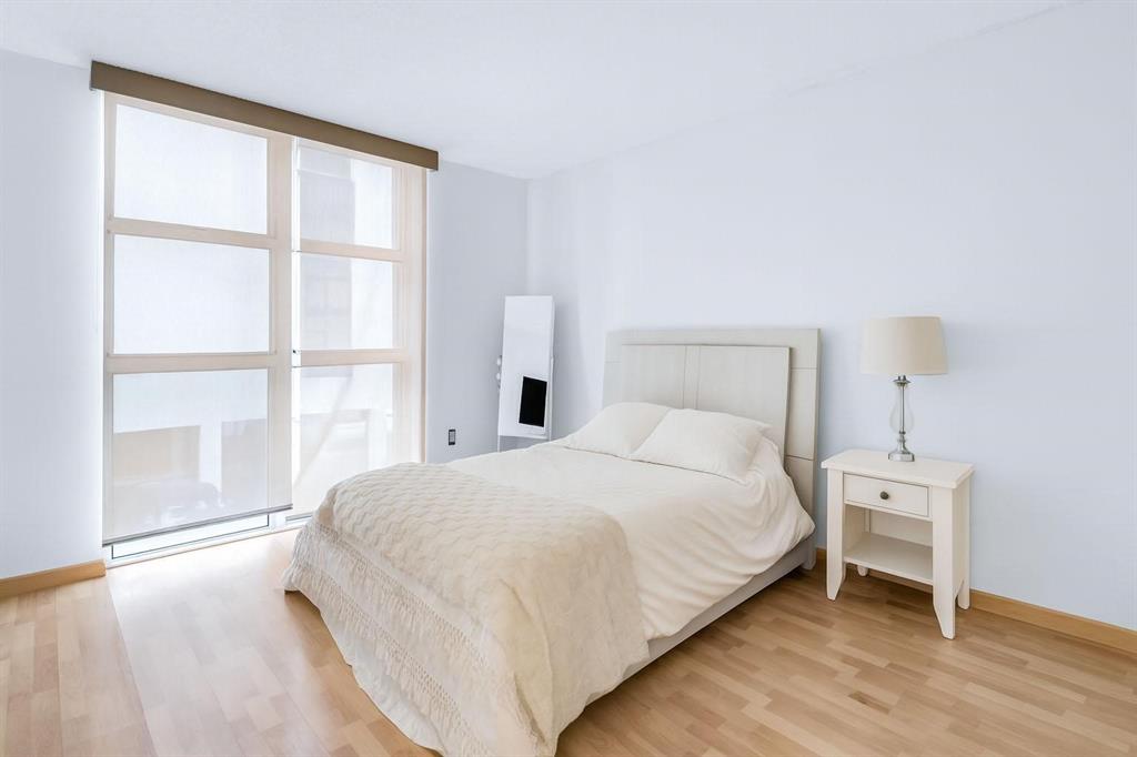 8855 Collins Avenue, Unit 2D Surfside, FL 33154 - Photo 9 of 25 a large bed sitting in a bedroom next to a window and a chair