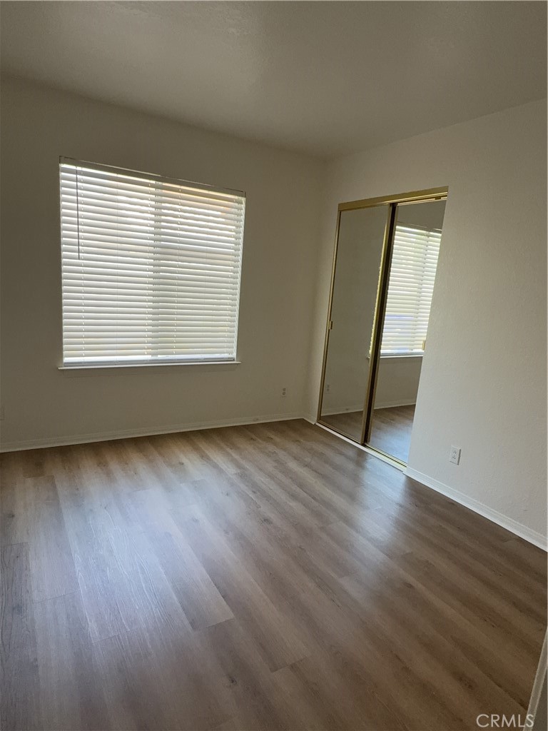 12590 Cobalt Road Victorville, CA 92392 - Photo 24 of 37 an empty room with wooden floor and windows