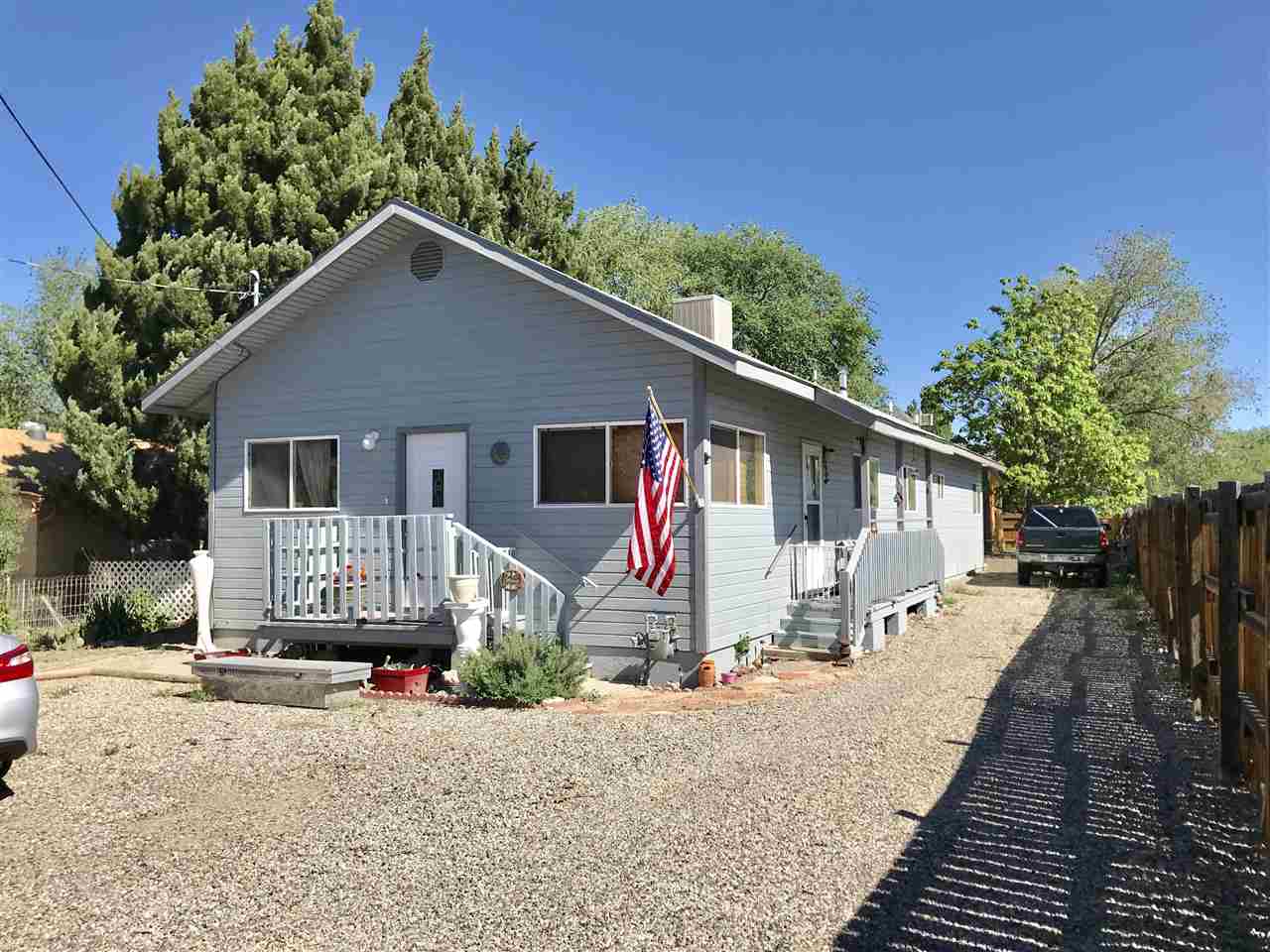 a front view of a house with a yard and potted plants
