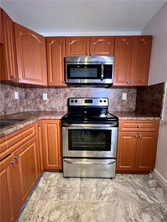 a kitchen with granite countertop a stove and a microwave