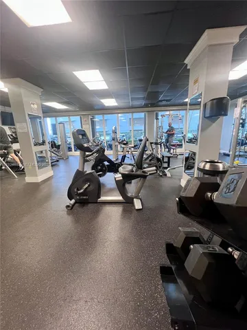 a gym room with lots of furniture and a equipment