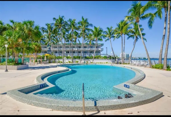 a view of a swimming pool with a lawn chairs under an umbrella