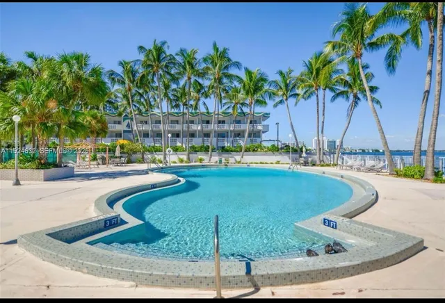 a view of a swimming pool with a lawn chairs under an umbrella