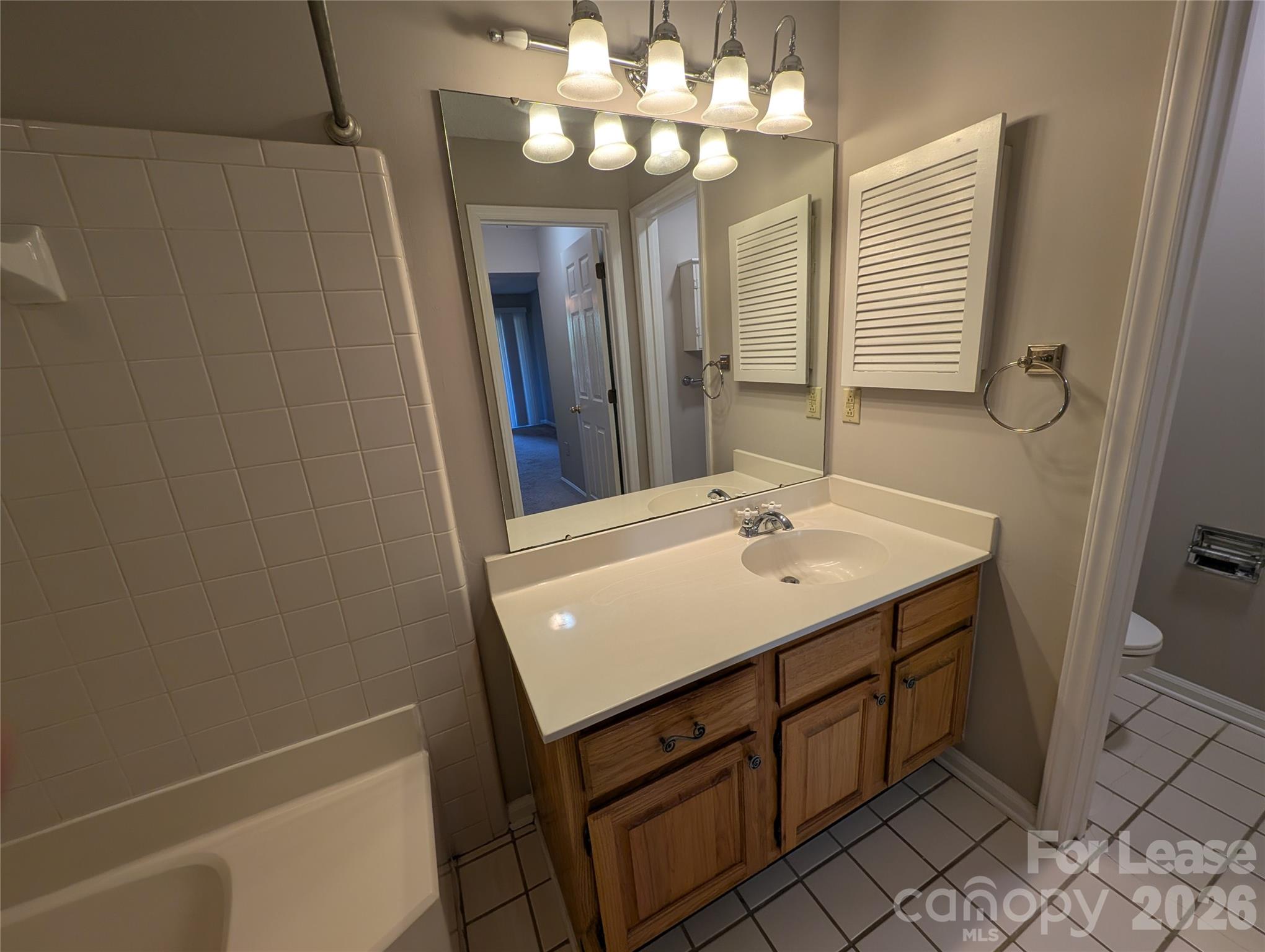 5001 Sharon Road, Unit K Charlotte, NC 28210 - Photo 22 of 24 a bathroom with a sink a light fixture and a mirror