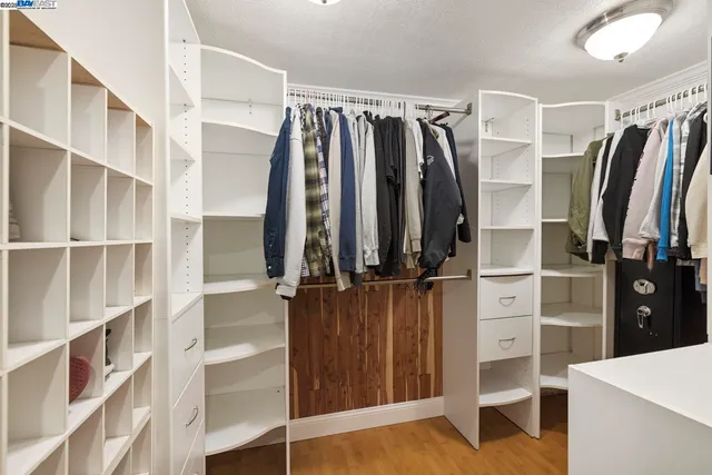 a view of walk in closet with clothes and shoes