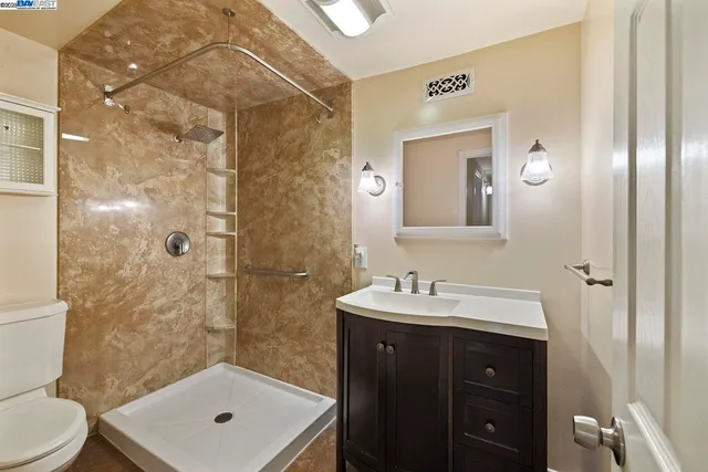 a bathroom with a sink a toilet and shower