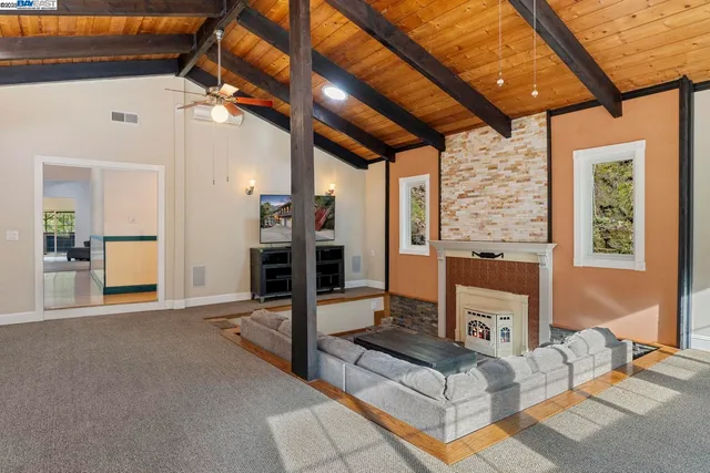 a living room with furniture a flat screen tv and next to a window