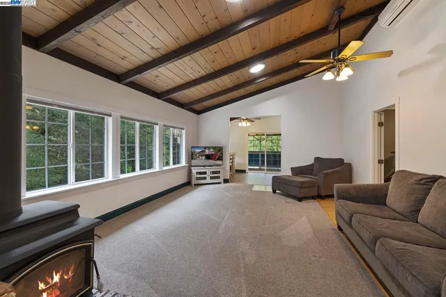 a living room with furniture a flat screen tv and a large window