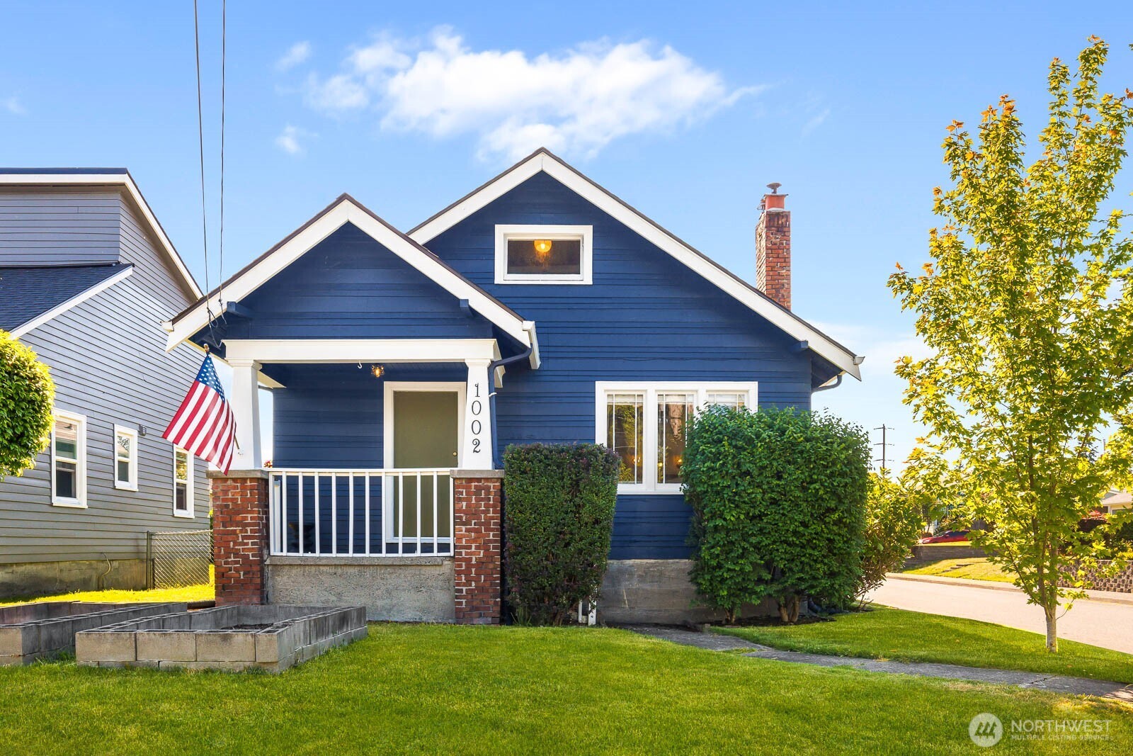 1002 South Adams Street Tacoma, WA 98405 - Photo 1 of 40 a view of a house with a small yard plants and a large tree