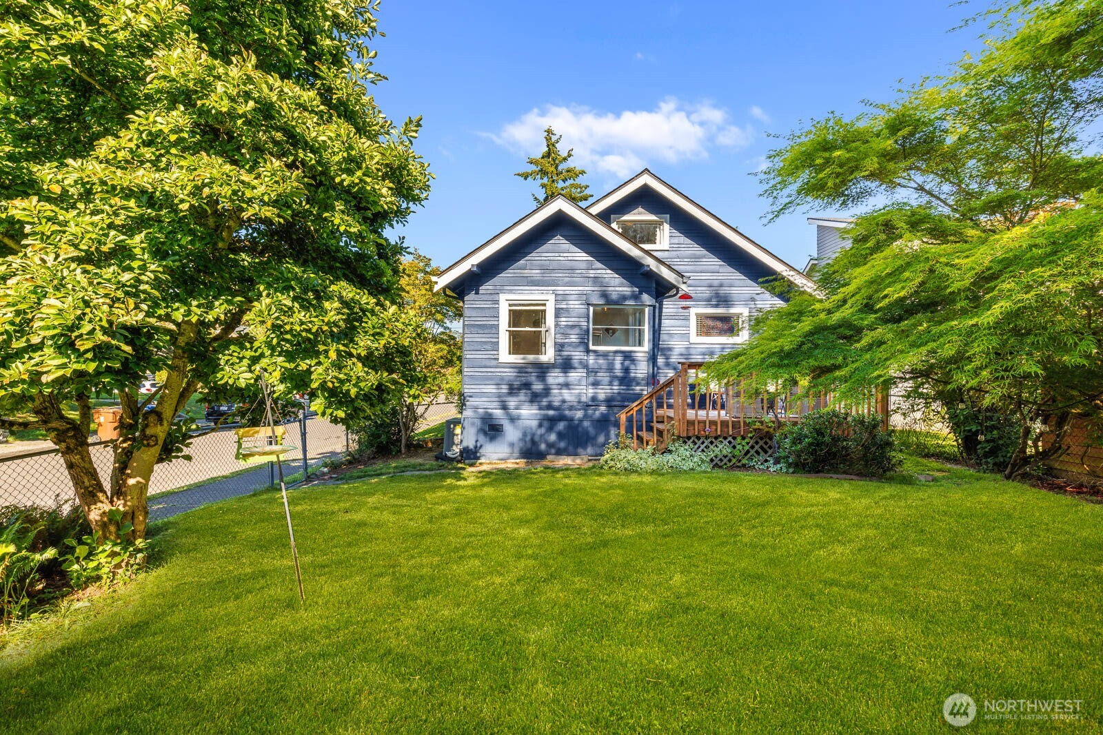1002 South Adams Street Tacoma, WA 98405 - Photo 31 of 40 a house that is sitting in the grass with large trees and plants