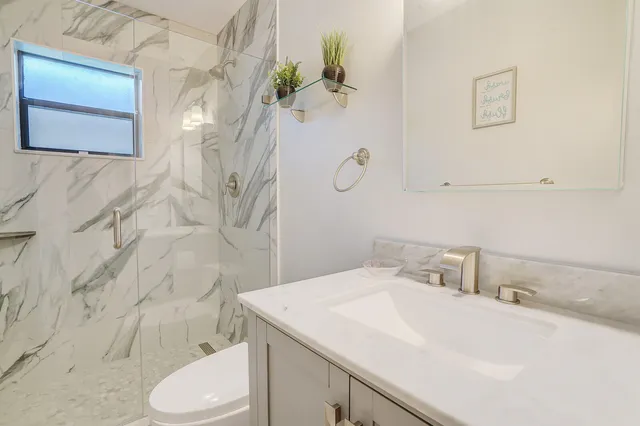 a bathroom with a sink toilet and shower