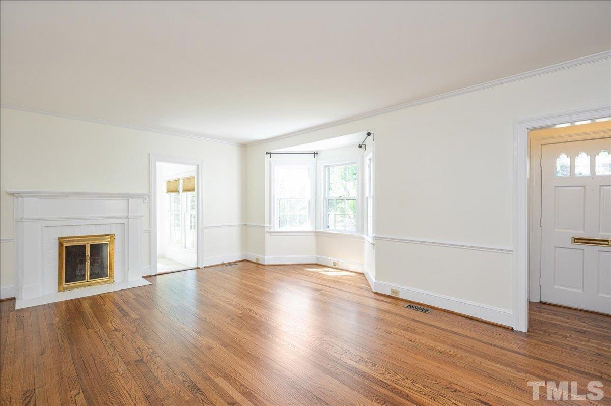 2511 Kenmore Drive Raleigh, NC 27608 - Photo 5 of 34 wood burning fireplace - access the light filled office/sunroom space off the living room