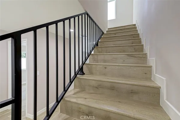 a view of a hallway with wooden floor and staircase