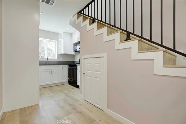 a kitchen with stainless steel appliances granite countertop white cabinets granite counter tops and a window