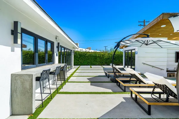 a view of swimming pool with lounge chair and dinning table under an umbrella