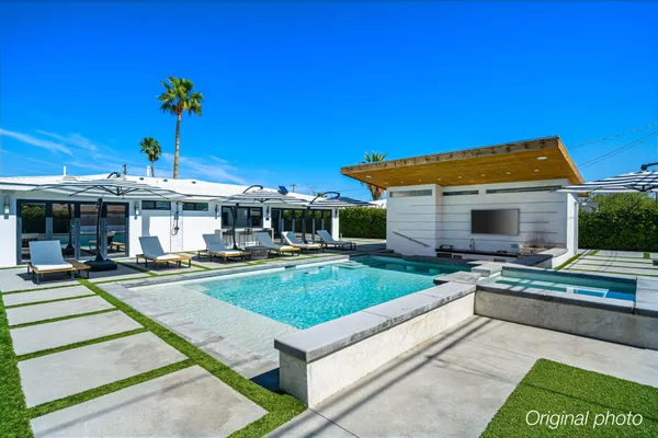 a view of a house with swimming pool and a table and chairs under an umbrella