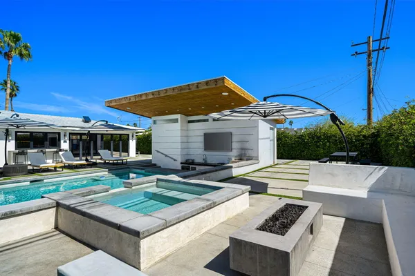 a view of a house with backyard sitting area and swimming pool