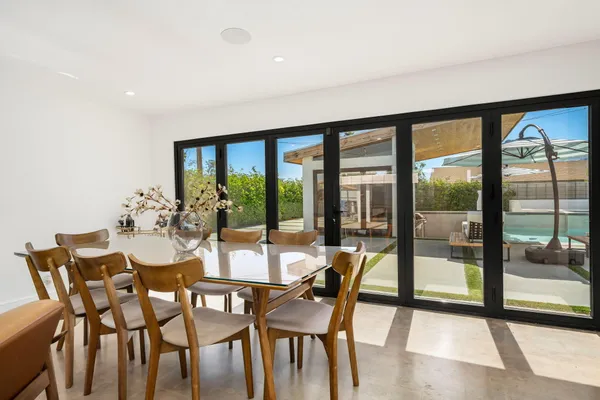 a view of a dining room with furniture and large windows