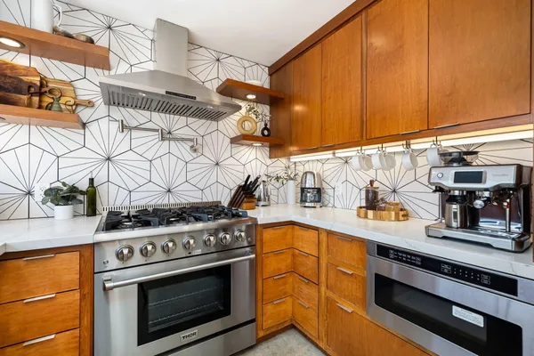 a kitchen with stainless steel appliances granite countertop a stove and a microwave
