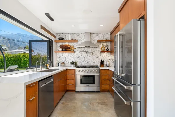a kitchen with stainless steel appliances granite countertop a stove and a refrigerator