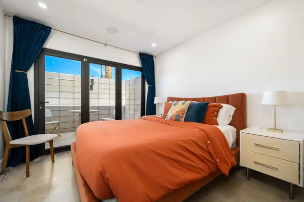 a bed sitting in a bedroom next to a window