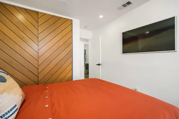 a bedroom with a bed and a flat screen tv