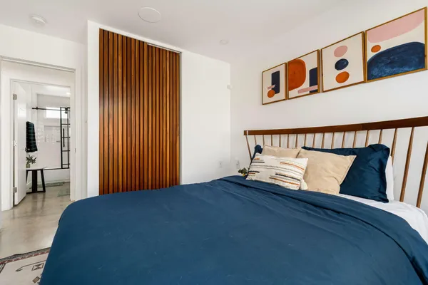 a bed sitting in a bedroom next to a bathroom