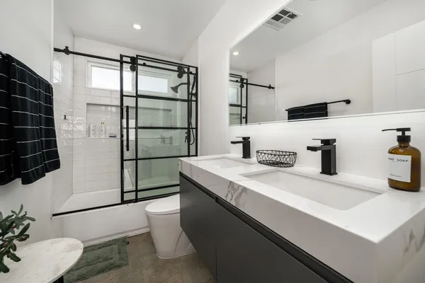 a bathroom with a sink a toilet and shower