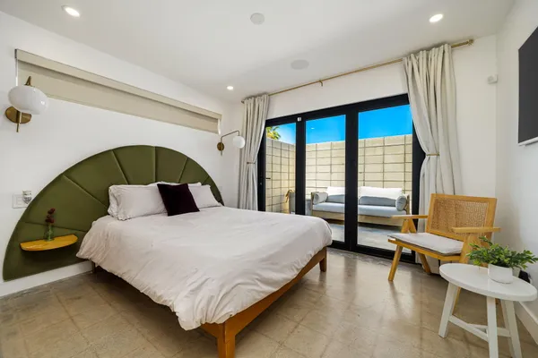 a bedroom with a bed chair and window