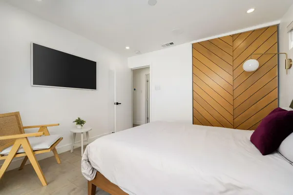 a bedroom with a bed and a flat screen tv