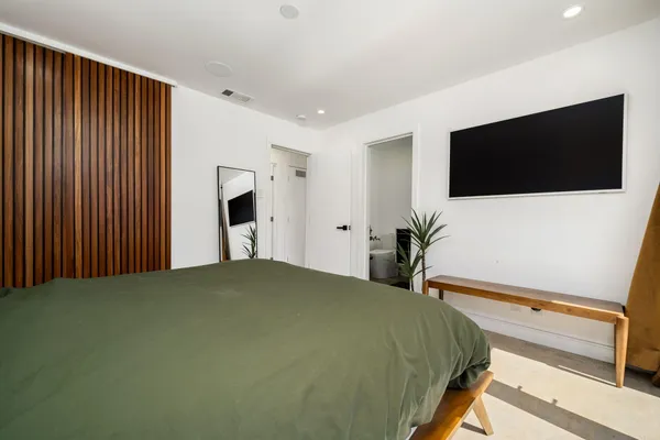 a bedroom with a bed and a flat screen tv