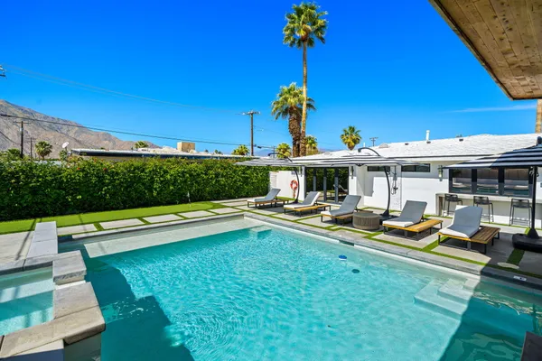 a view of a house with swimming pool and sitting area