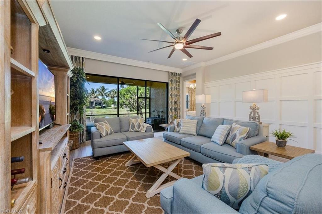 13422 Silktail Drive Naples, FL 34109 - Photo 11 of 37 Living area featuring dark wood finished floors, ceiling fan, ornamental molding, and a decorative wall