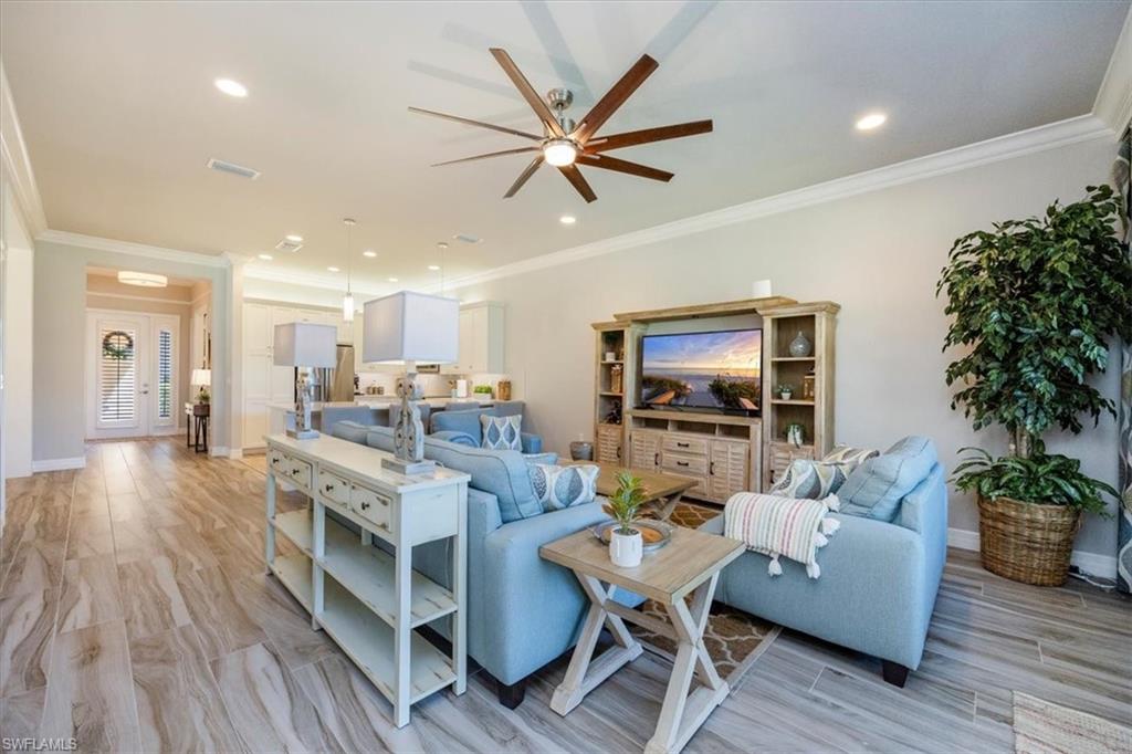 13422 Silktail Drive Naples, FL 34109 - Photo 12 of 37 Living area with visible vents, baseboards, a ceiling fan, and ornamental molding