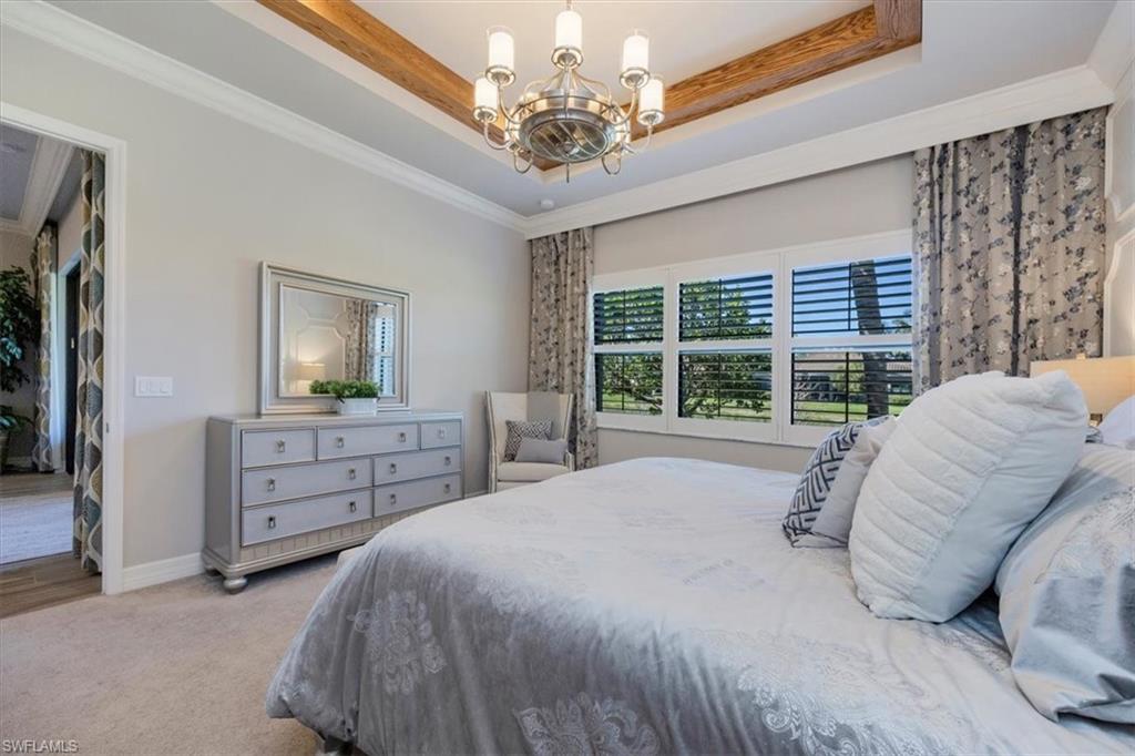 13422 Silktail Drive Naples, FL 34109 - Photo 14 of 37 Bedroom featuring a raised ceiling, a notable chandelier, carpet, and ornamental molding