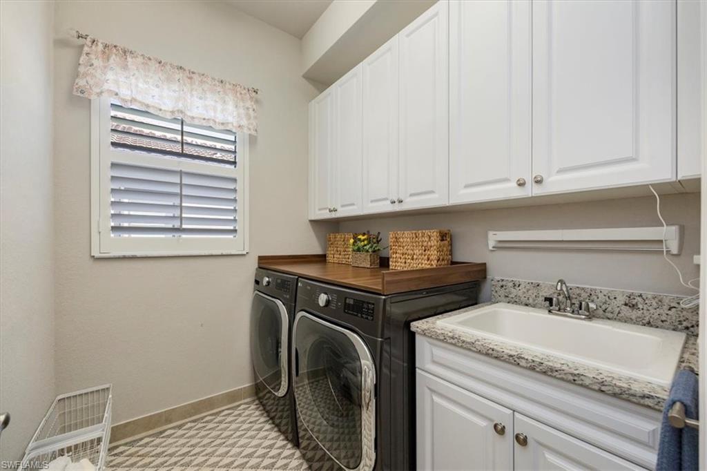 13422 Silktail Drive Naples, FL 34109 - Photo 22 of 37 Laundry area with cabinet space, washing machine and dryer, baseboards, and a sink