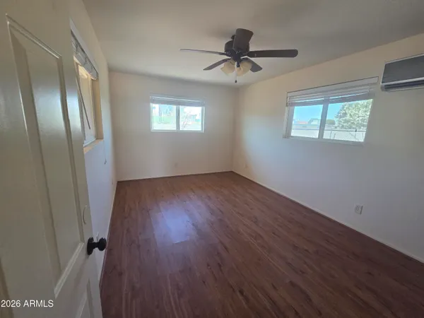 a view of a room with wooden floor closet and windows