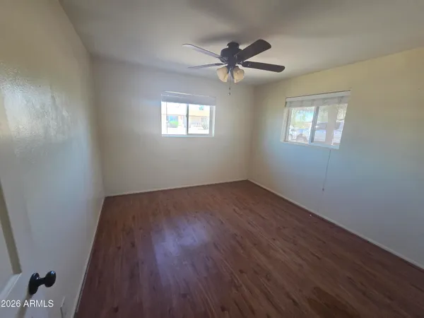 a view of a room with wooden floor and windows
