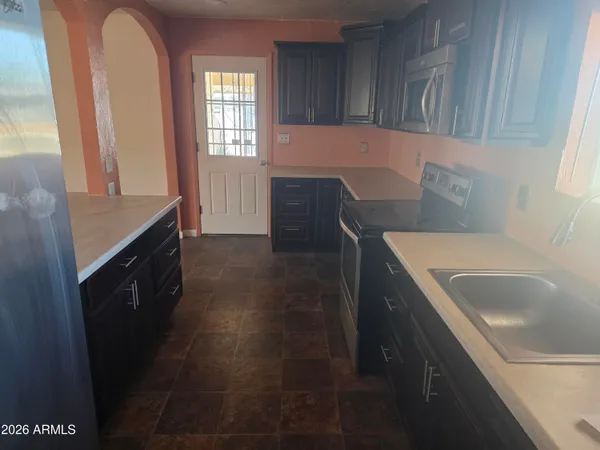 a kitchen with a sink a stove and cabinets