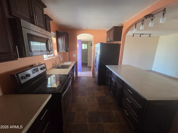 a kitchen with stainless steel appliances granite countertop a stove a sink and a microwave