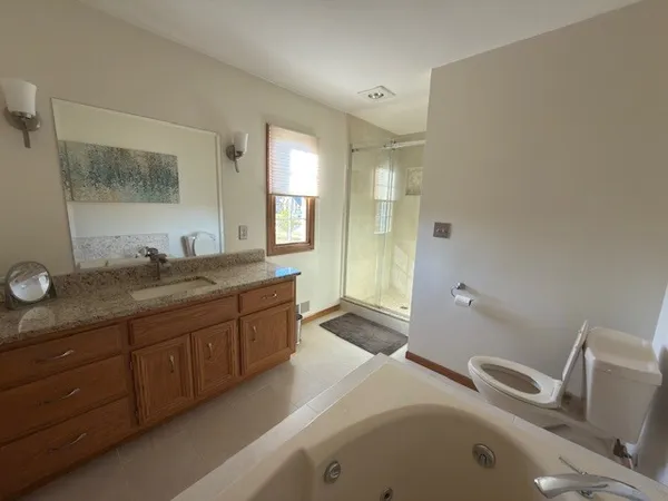 a spacious bathroom with a granite countertop sink and a mirror