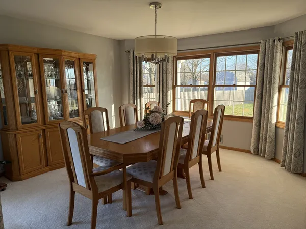 a dining room with furniture a chandelier and wooden floor