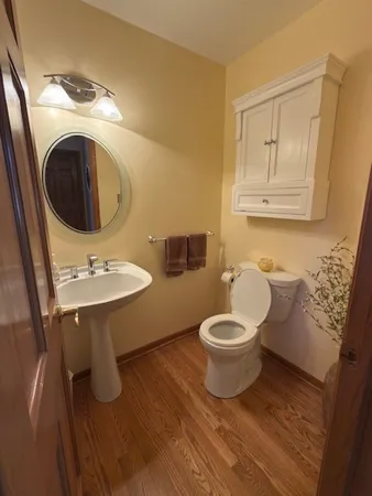 a bathroom with a toilet a sink and mirror