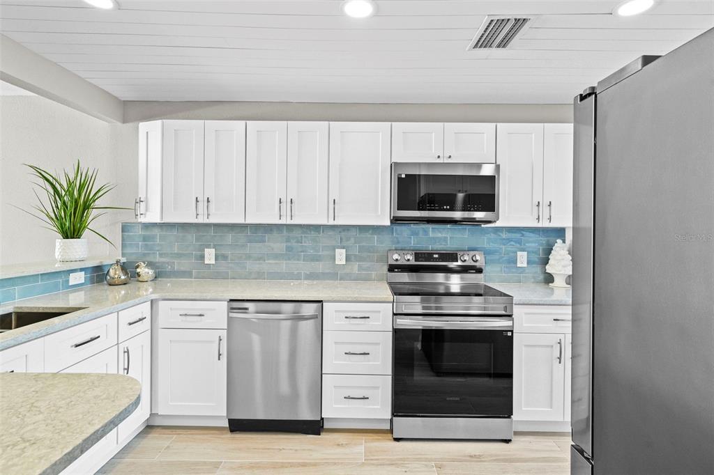 642 Boca Ciega Point Boulevard South St. Petersburg, FL 33708 - Photo 20 of 54 a kitchen with white cabinets and appliances
