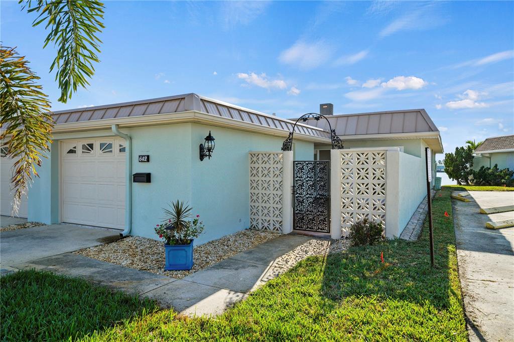 642 Boca Ciega Point Boulevard South St. Petersburg, FL 33708 - Photo 2 of 54 a view of a house with small yard plants and a lawn chair