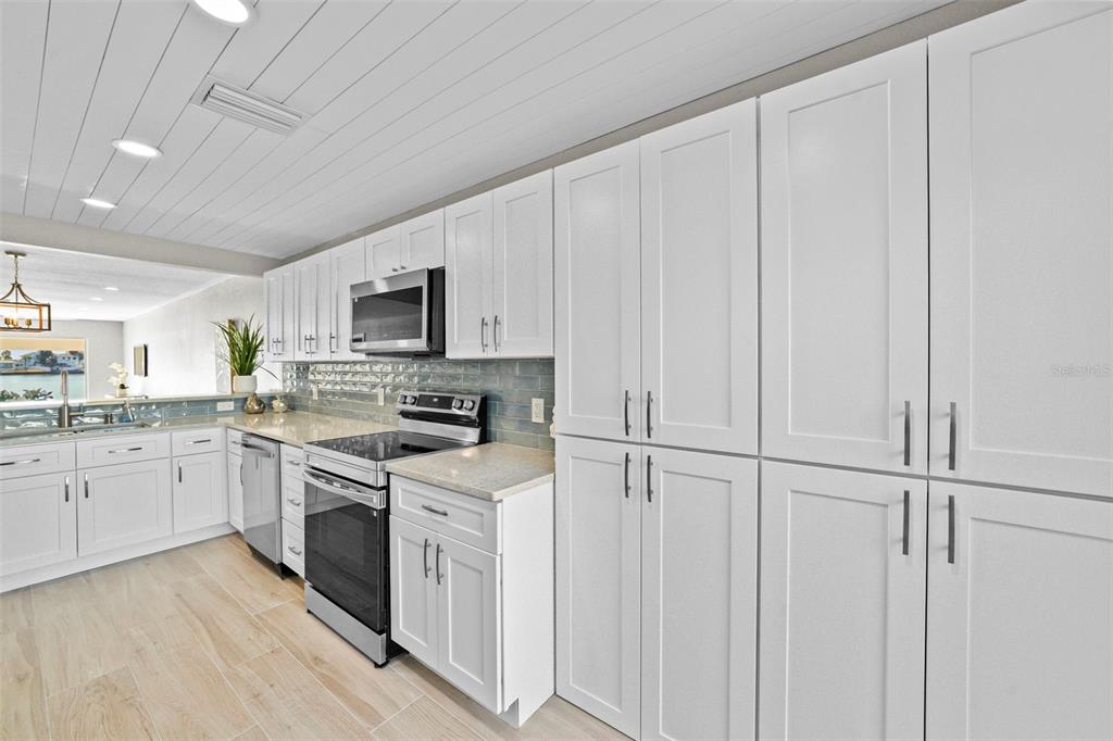 642 Boca Ciega Point Boulevard South St. Petersburg, FL 33708 - Photo 21 of 54 a kitchen with white cabinets and white appliances