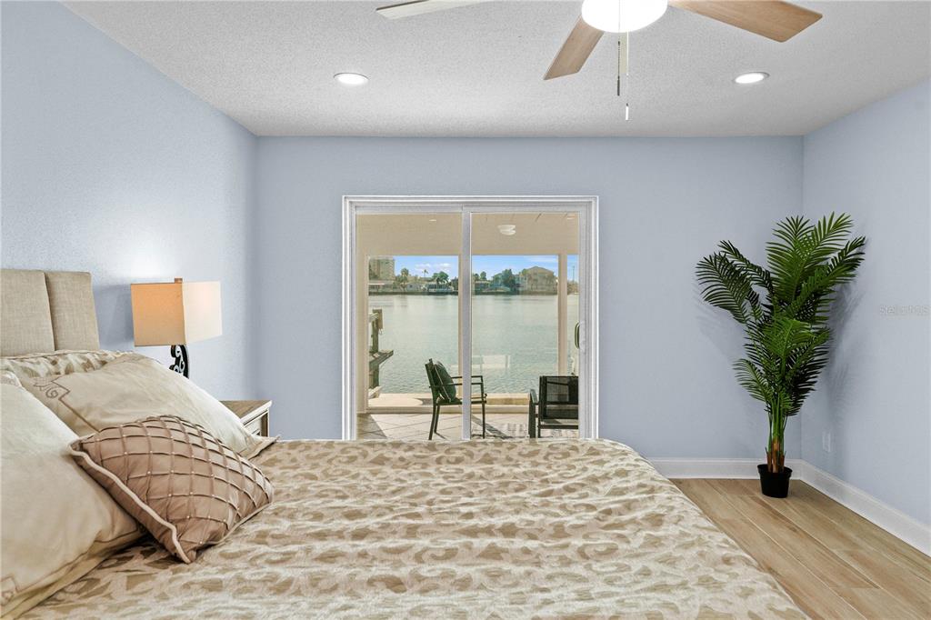 642 Boca Ciega Point Boulevard South St. Petersburg, FL 33708 - Photo 25 of 54 a bedroom with a large bed and a potted plant