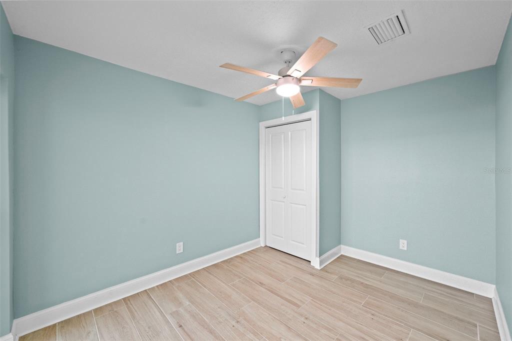 642 Boca Ciega Point Boulevard South St. Petersburg, FL 33708 - Photo 30 of 54 an empty room with wooden floor and fan